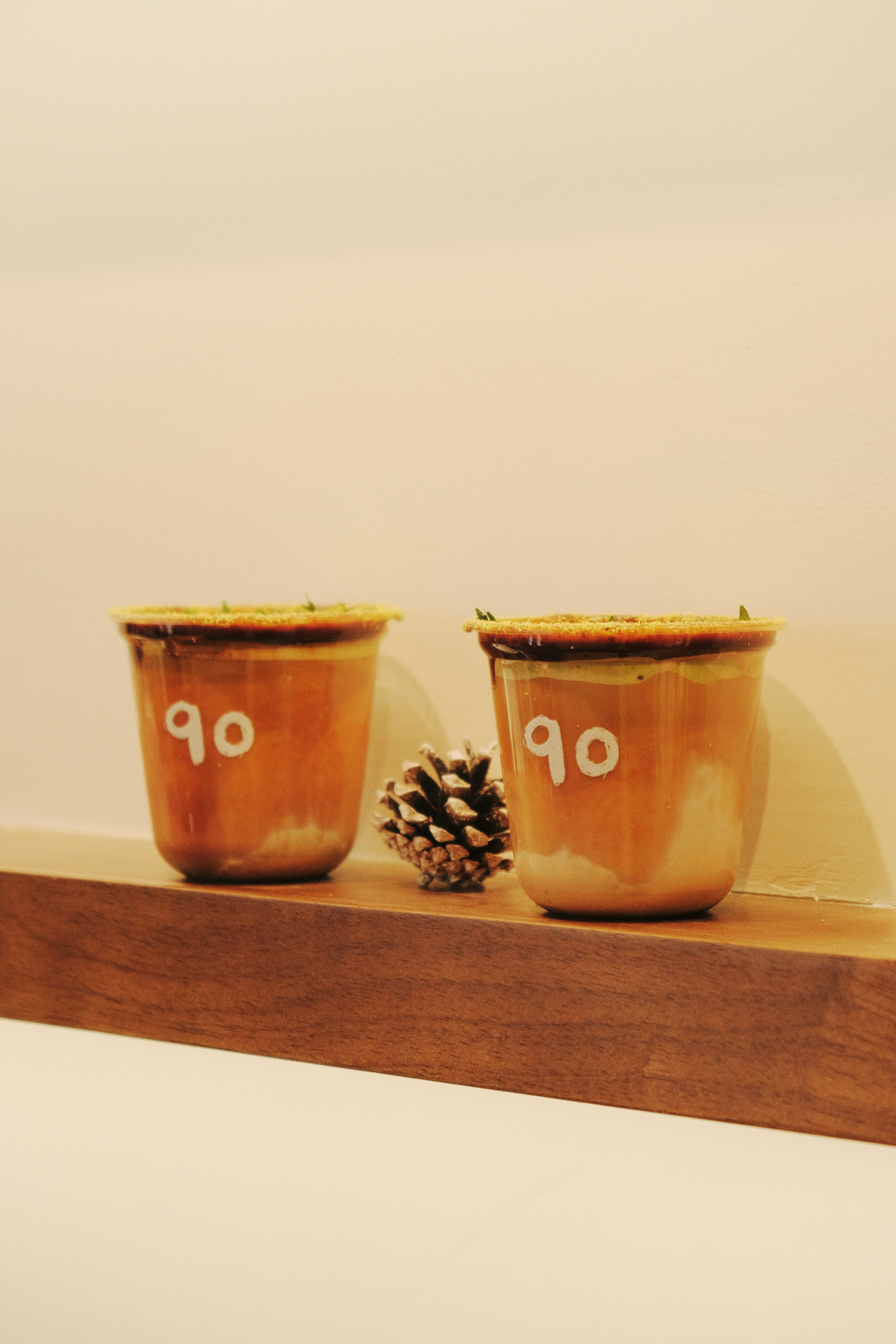 Eco-friendly custom ceramic cups with eco motifs on a wooden table.